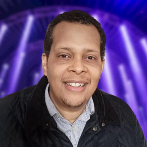 Garnett Banfield, founder of Meridian SEO, smiling in front of purple stage lighting